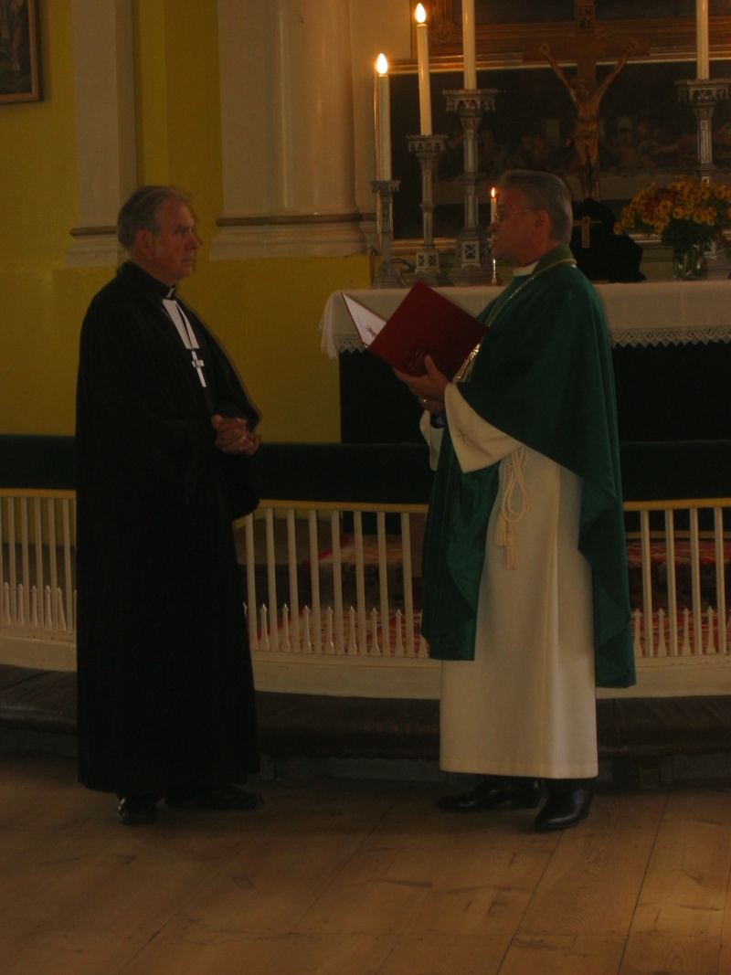Peapiiskop Andres Põder annab õpetaja Peep Audovale üle teeneteristi.