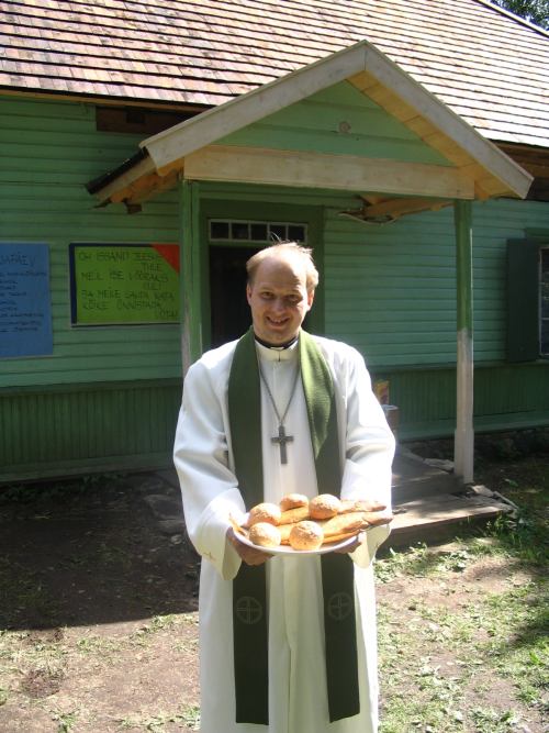 Tanel Ots lastelaagri jumalateenistusel jagamas sümboolset armulauda ehk «viit leiba ja kaht kala».