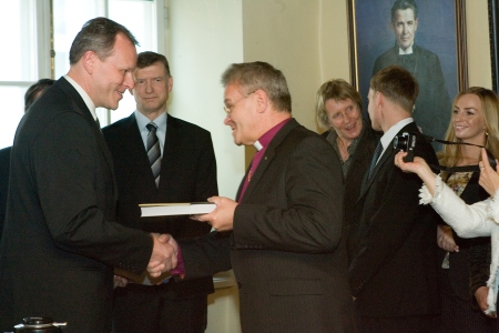 Hõimusõprus Soome ja Eesti luterliku kiriku vahel: peapiiskop Andres Põder kingib Soome kiriku infojuhile Tuomi Pesonenile raamatu.