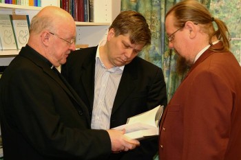 Siim Valmar Kiisler (keskel) tutvub koos Tiit Salumäe ja Jaan Bärensoniga piibliseltsis müügil oleva kirjandusega. Foto: Mikk Leedjärv
