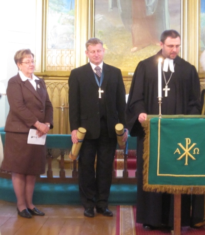 Naani Holsmer (vasakult), Valdek Tagel ja Ants Tooming  valmistuvad alla kirjutama kahe koguduse vahelisele sõpruslepingule. Rita Puidet