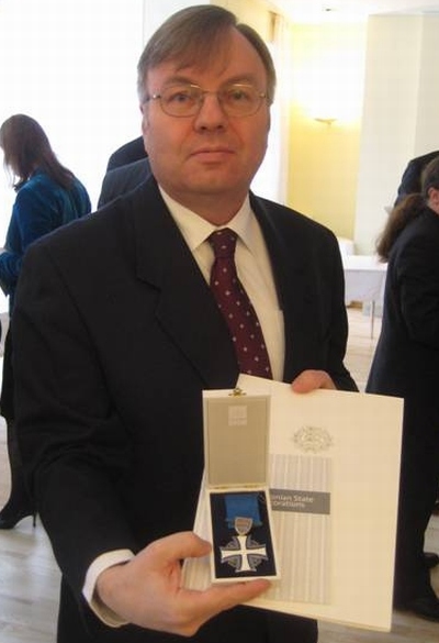 Göran Grahn näitab Eesti presidendi otsusega saadud teenetemärki, mida hakkab enda sõnul kandma suure uhkusega.  Erakogu